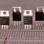 A close-up of electronic transistors on a circuit board.